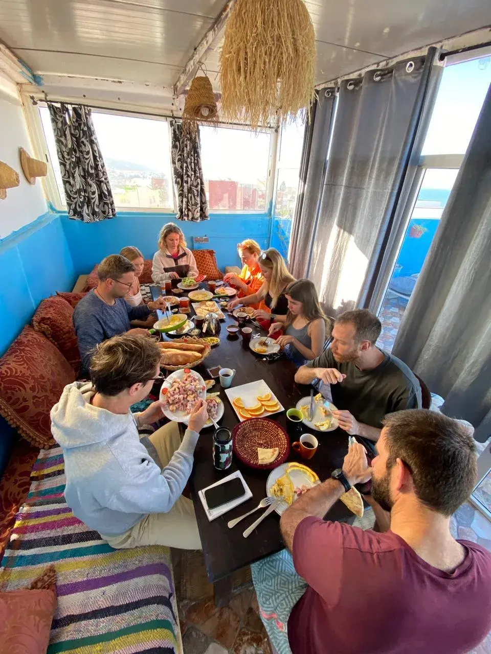 Guests sharing a meal around a long table in the blue-walled dining room